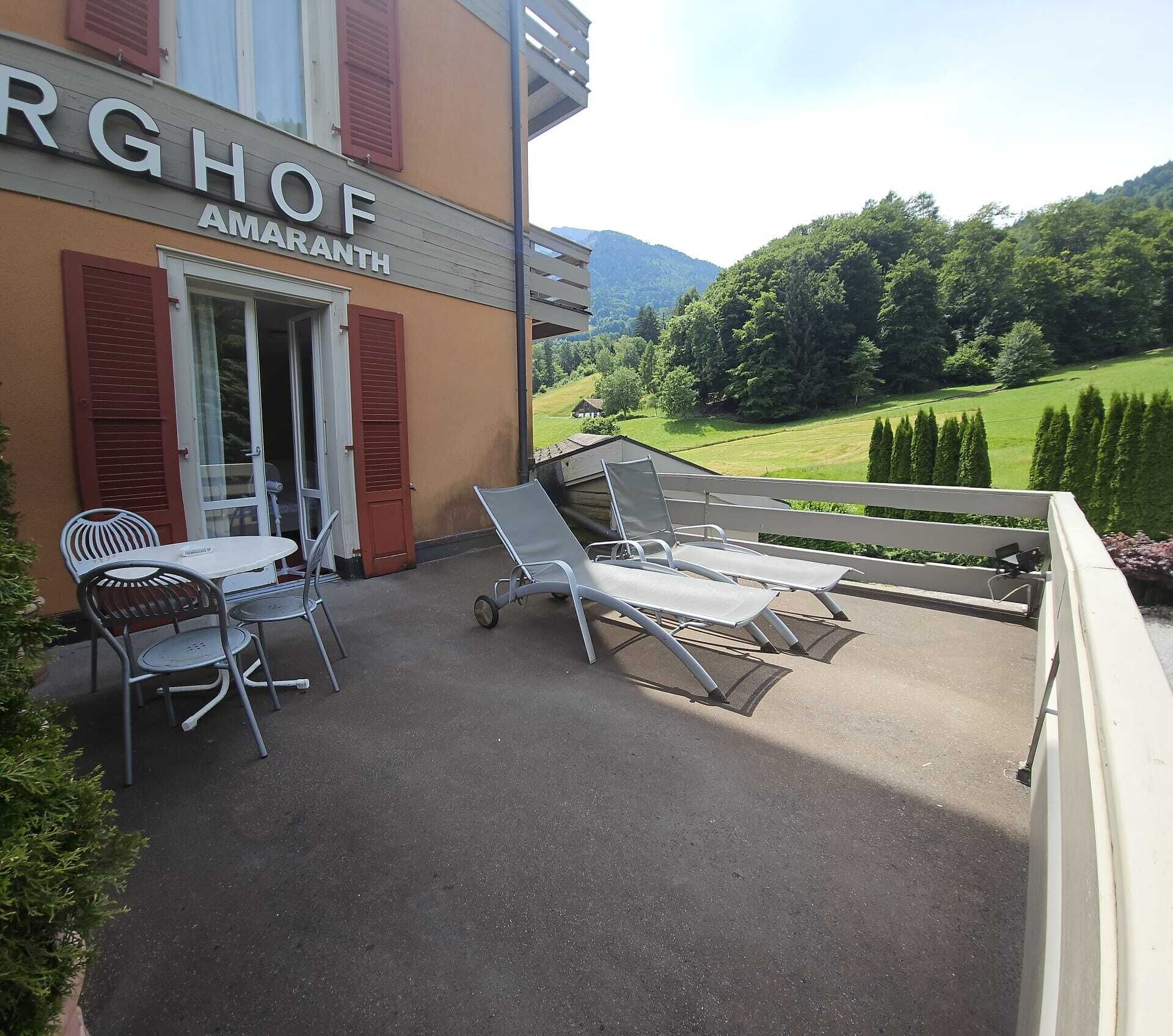 Un patio de hotel con asientos al aire libre, una mesa y sillas.