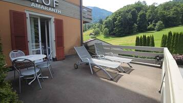 A hotel patio with outdoor seating, a table, and chairs.