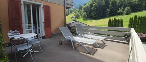 Un patio de hotel con asientos al aire libre, una mesa y sillas.