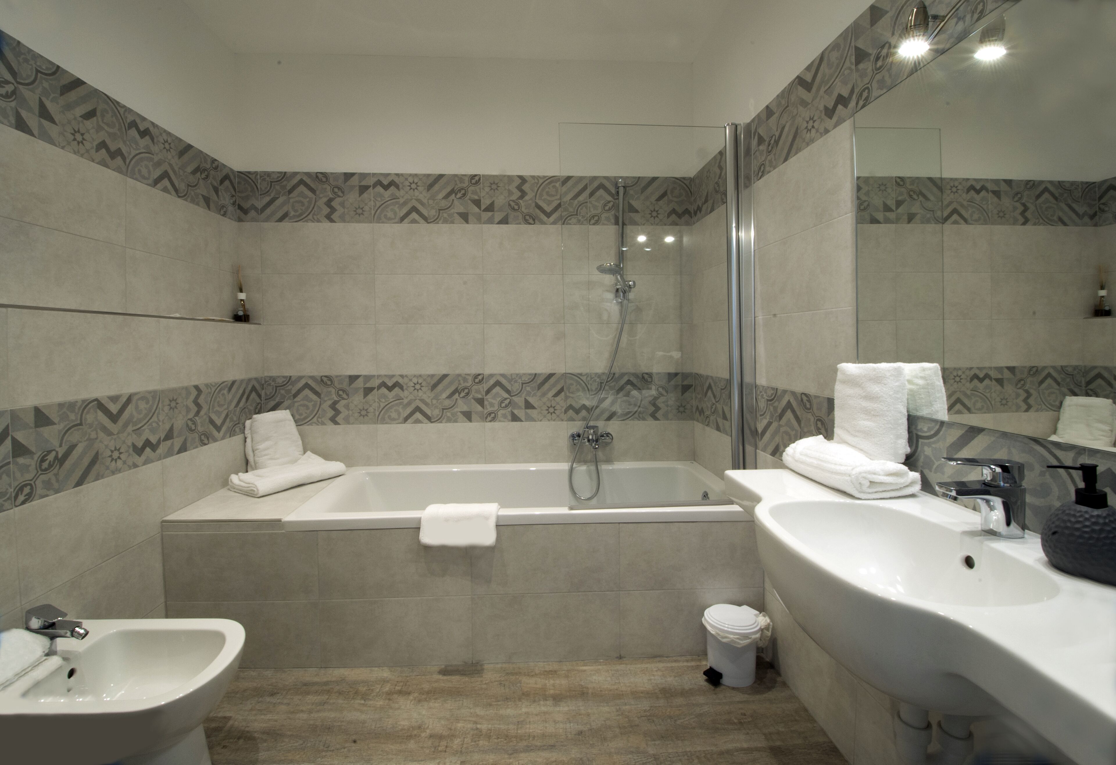 Un bagno moderno con vasca, doccia, lavabo e bidet.