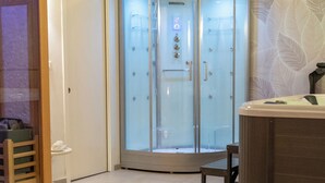 Un baño moderno con cabina de ducha de vidrio, banco de madera y bañera de hidromasaje.
