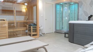 Un spa moderno con sauna, camilla de masaje y ducha de vapor.
