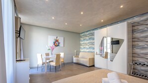Una habitación de hotel moderna con cama, escritorio, silla, sofá y un espejo grande.