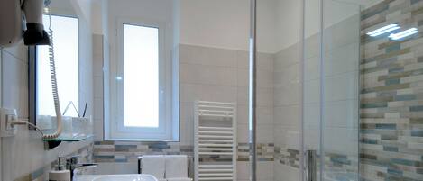 A modern bathroom with a glass shower enclosure, a large sink, and a toilet.