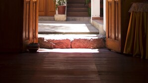 An open wooden door leading to a staircase with a potted plant on the landing. - Posada Nueva España (Arequipa)