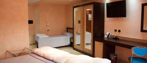Una habitación de hotel con una cama, un escritorio, una silla, un espejo y un televisor.