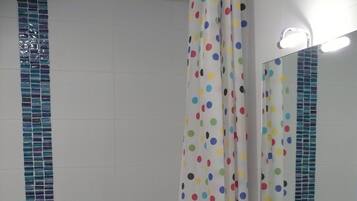 Un baño con una bañera blanca, un lavamanos blanco y un espejo sobre el lavamanos.
