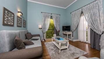 Junior suite | Woonkamer | Een 72-cm televisie met kabelzenders en boeken