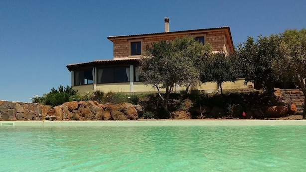 A coastal house with a clear view of the turquoise sea.