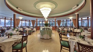 A formal dining room with multiple tables, chairs, and a central floral arrangement. - Hotel Terme Imperial (Montegrotto Terme)