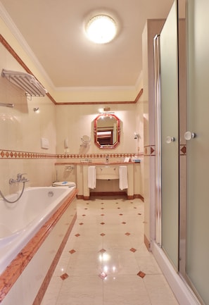 A bathroom with a bathtub, a shower, a sink, and a mirror. - Hotel Terme Imperial (Montegrotto Terme)