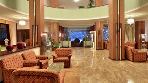 A spacious lobby with a grand chandelier, comfortable seating, and a large aquarium. - Hotel Terme Imperial (Montegrotto Terme)