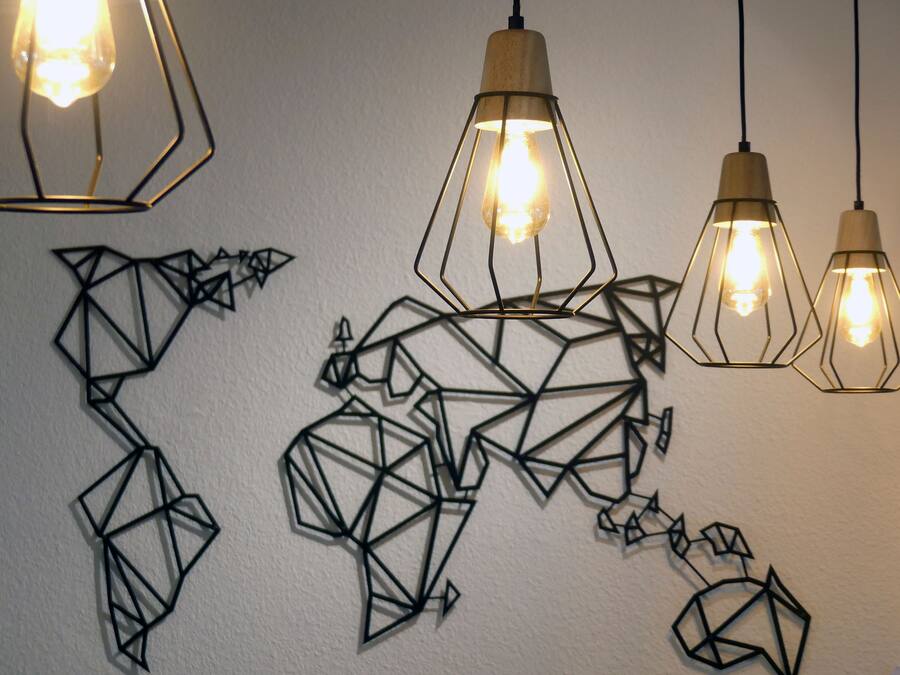 Eine Wand mit geometrischer Wandkunst und Pendelleuchten.