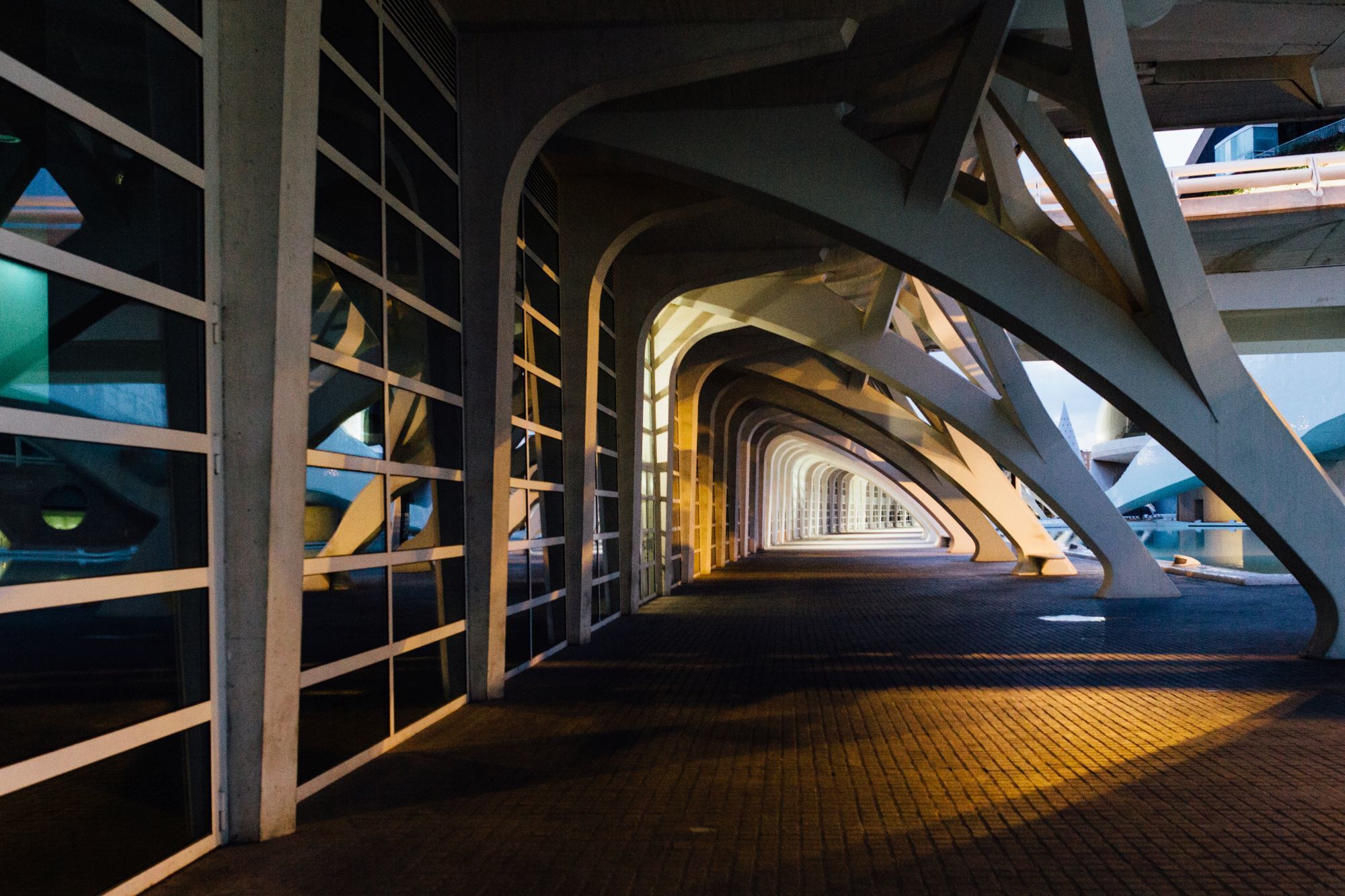 Una estructura arquitectónica con una serie de arcos y un paseo empedrado.