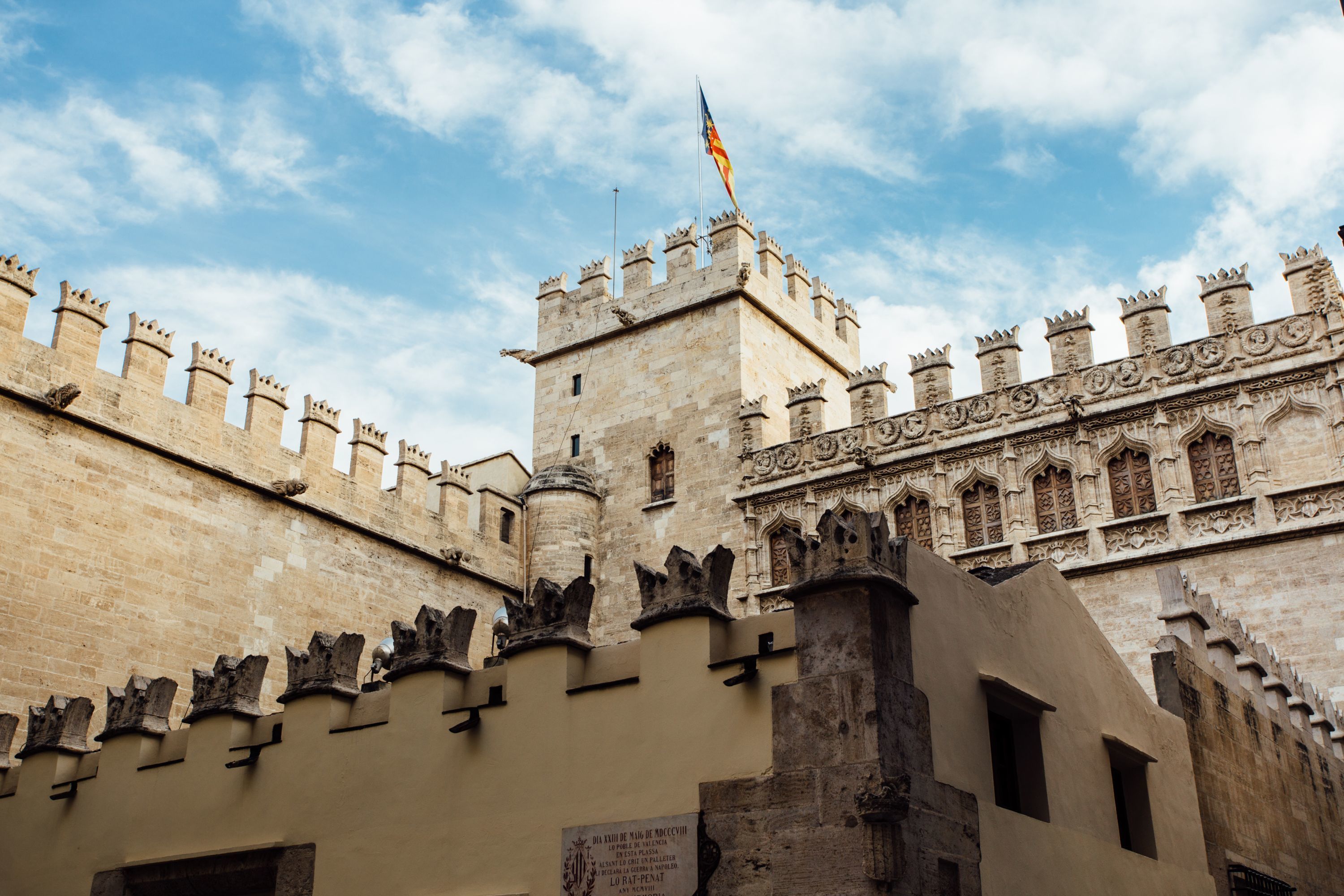 A historic stone building with crenellated battlements and a flagpole.