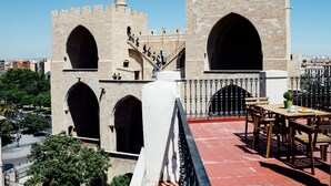 Un château historique en pierre, doté d’arcades et d’un escalier menant aux niveaux supérieurs.