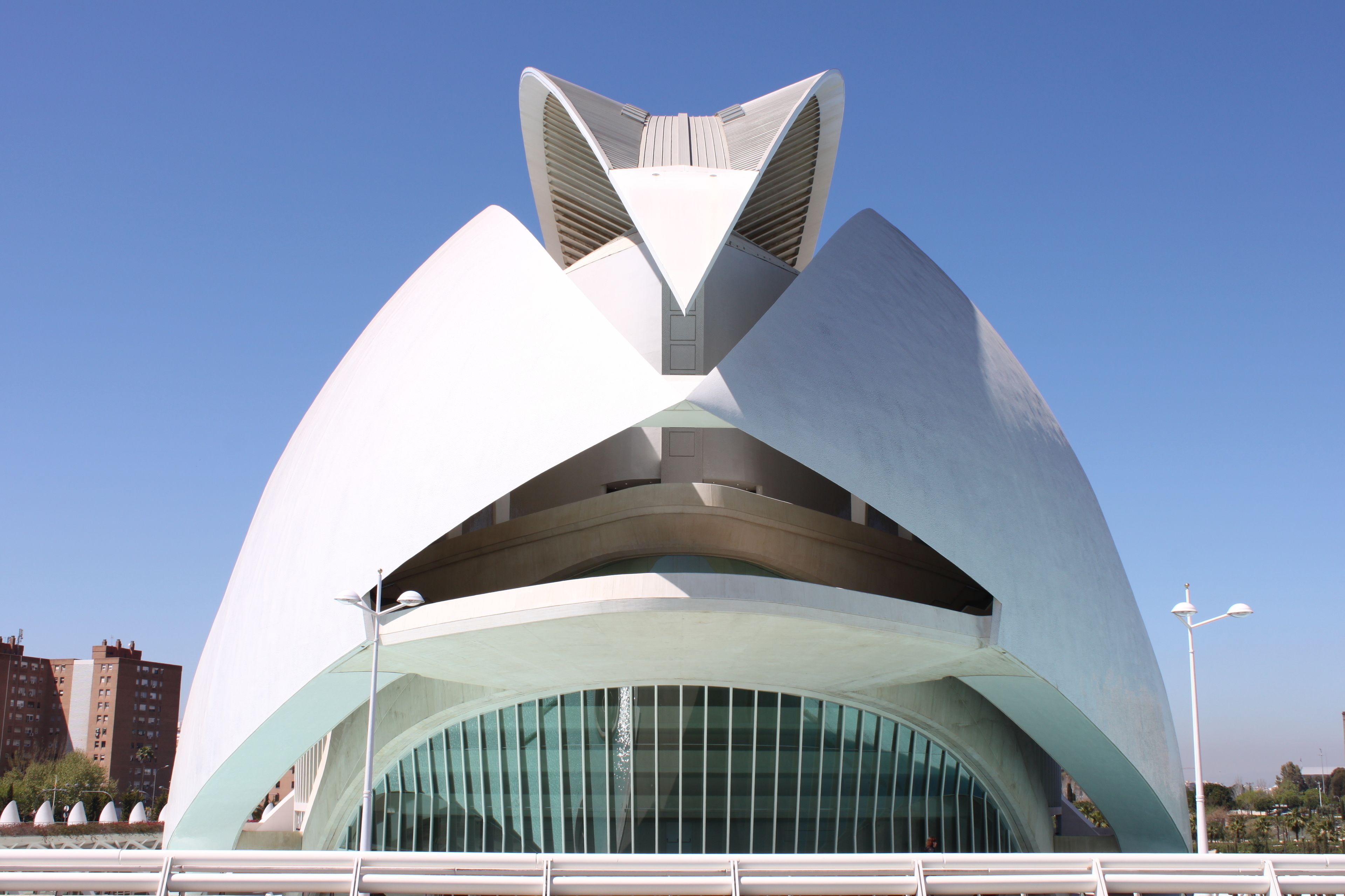 A modern architectural building with a unique, curved design and large glass windows.