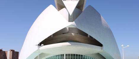 A modern architectural building with a unique, curved design and large glass windows.