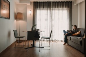 A modern living room with a dining area, a sofa, and a lamp. - Parker The Urban Flats (Valencia)
