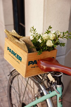A bicycle with a wooden box attached to the rear, containing a bouquet of flowers and burlap. - Parker The Urban Flats (Valencia)