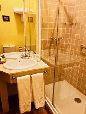 Habitación doble económica | Baño | Tina con regadera, amenidades de baño gratuitas, secadora de cabello 