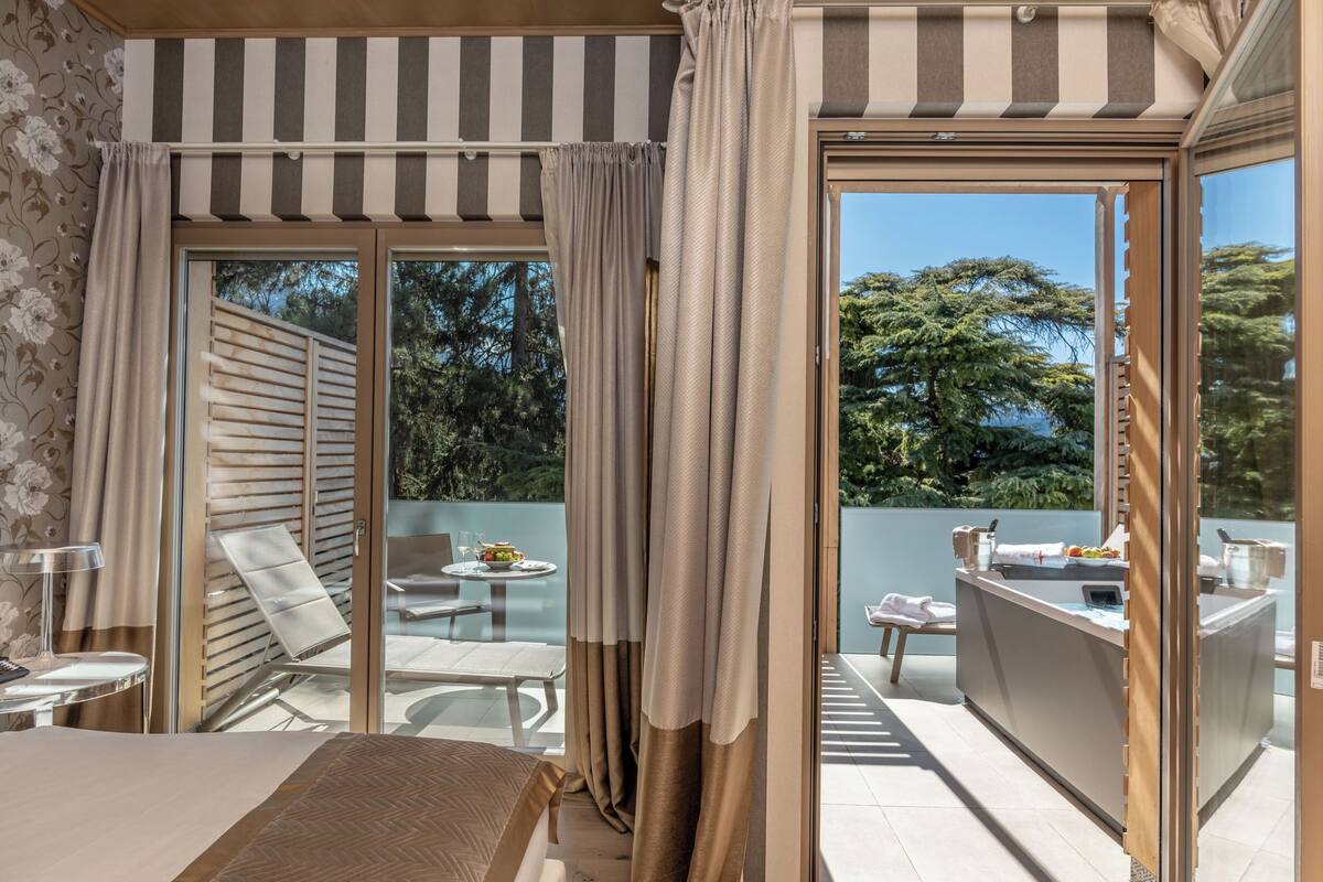 Ein Hotelzimmer mit Balkon, Essbereich und Blick ins Freie.