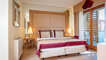 A modern bedroom with a large bed, two bedside tables with lamps, a wooden headboard, and a sliding glass door to a balcony.