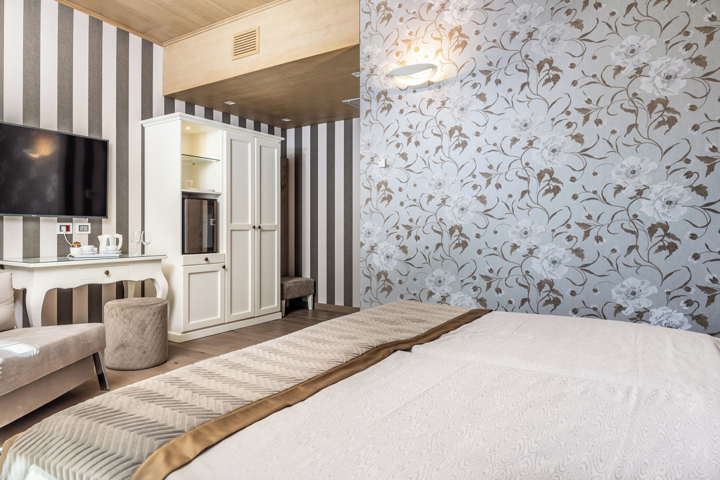 Ein Hotelzimmer mit Bett, Fernseher, Schreibtisch und Kleiderschrank.