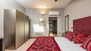 Camera da letto moderna con un letto grande, un armadio, uno specchio e una testiera imbottita rossa.