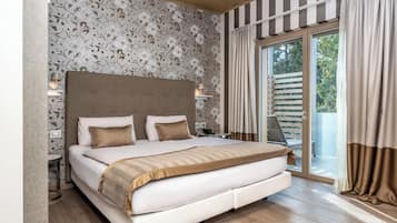 A large bed with a headboard, bedside tables, and a view of the outdoors through a sliding glass door.