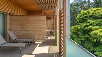 Un espacio de estar moderno al aire libre con listones de madera y vistas a follaje exuberante.