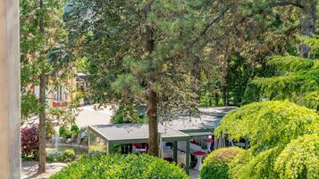 A courtyard with a gazebo, surrounded by lush greenery and trees.