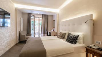 Una habitación de hotel con una cama grande, un escritorio, una silla y un televisor.