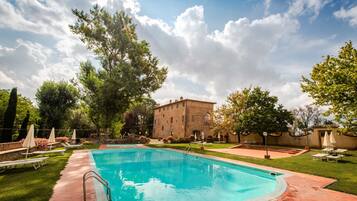 Una piscina al aire libre de temporada, sombrillas