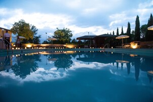 Una piscina al aire libre de temporada, sombrillas