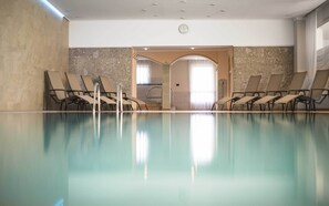 Una piscina techada, sillones reclinables de piscina