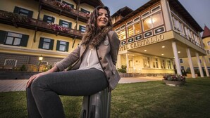 A hotel with a traditional European architectural style, featuring a prominent entrance and a balcony with flowers. - Hotel Cristallo (Dobbiaco)