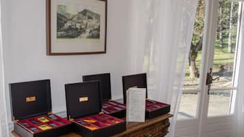 Three open jewelry boxes on a wooden table with a framed picture above.