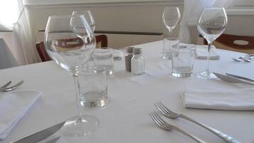 A table set for dining with wine glasses, water glasses, and cutlery.