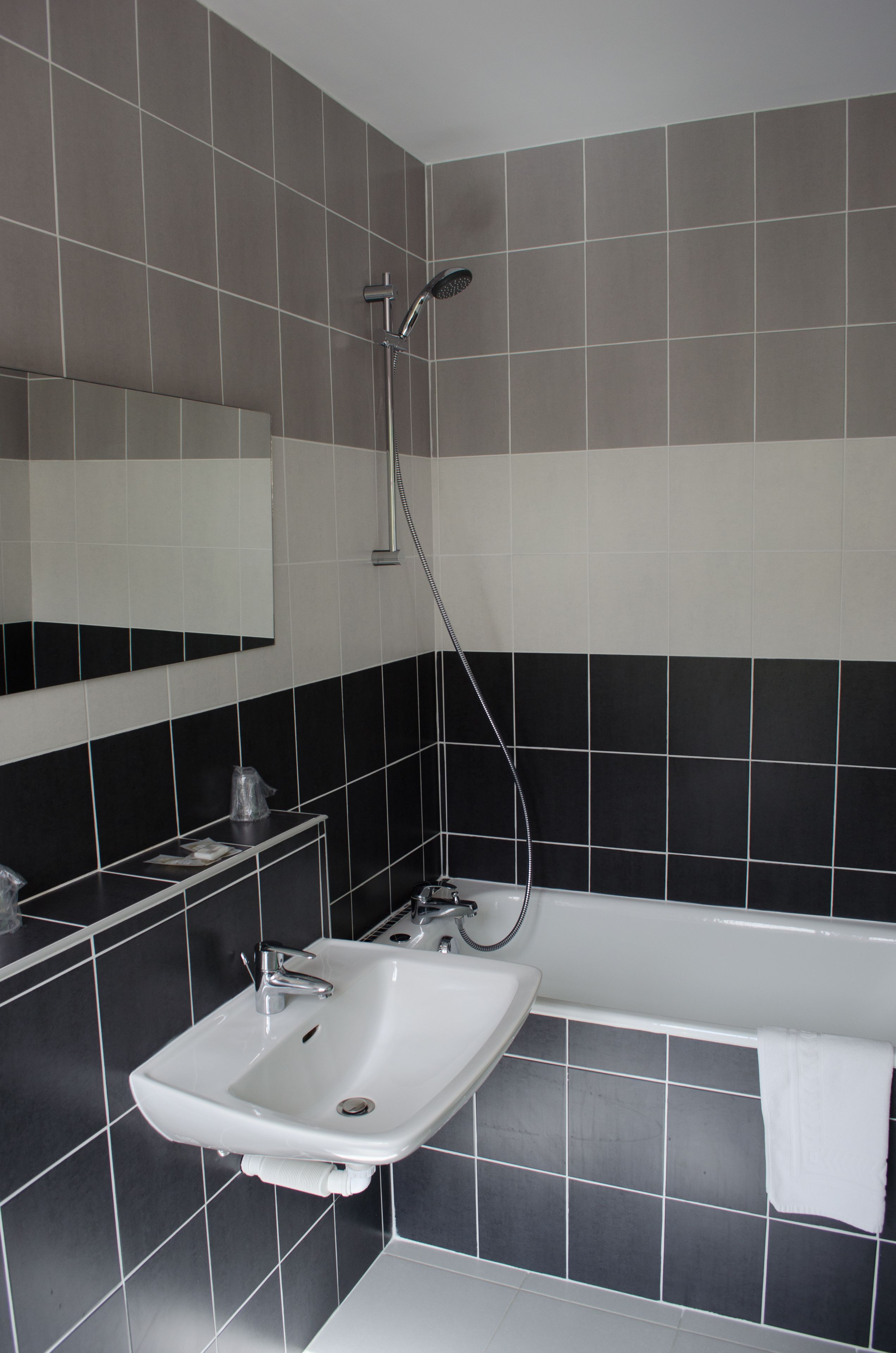 Ein Badezimmer mit einem weißen Waschbecken, einem Spiegel und einer Badewanne.