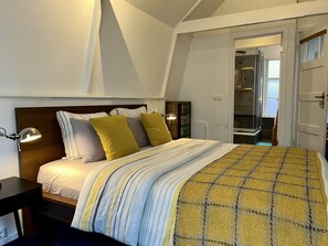 Un dormitorio con cama, lámparas de noche y ventana.