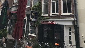 A row of traditional European-style buildings with a restaurant named "Diná" and a shop called "Leemans". - Amsterdam4holiday (Amsterdam)