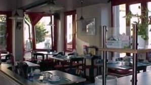 A restaurant interior with tables, chairs, and a counter.