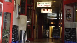 A hotel entrance with a sign indicating a restaurant and reception area.