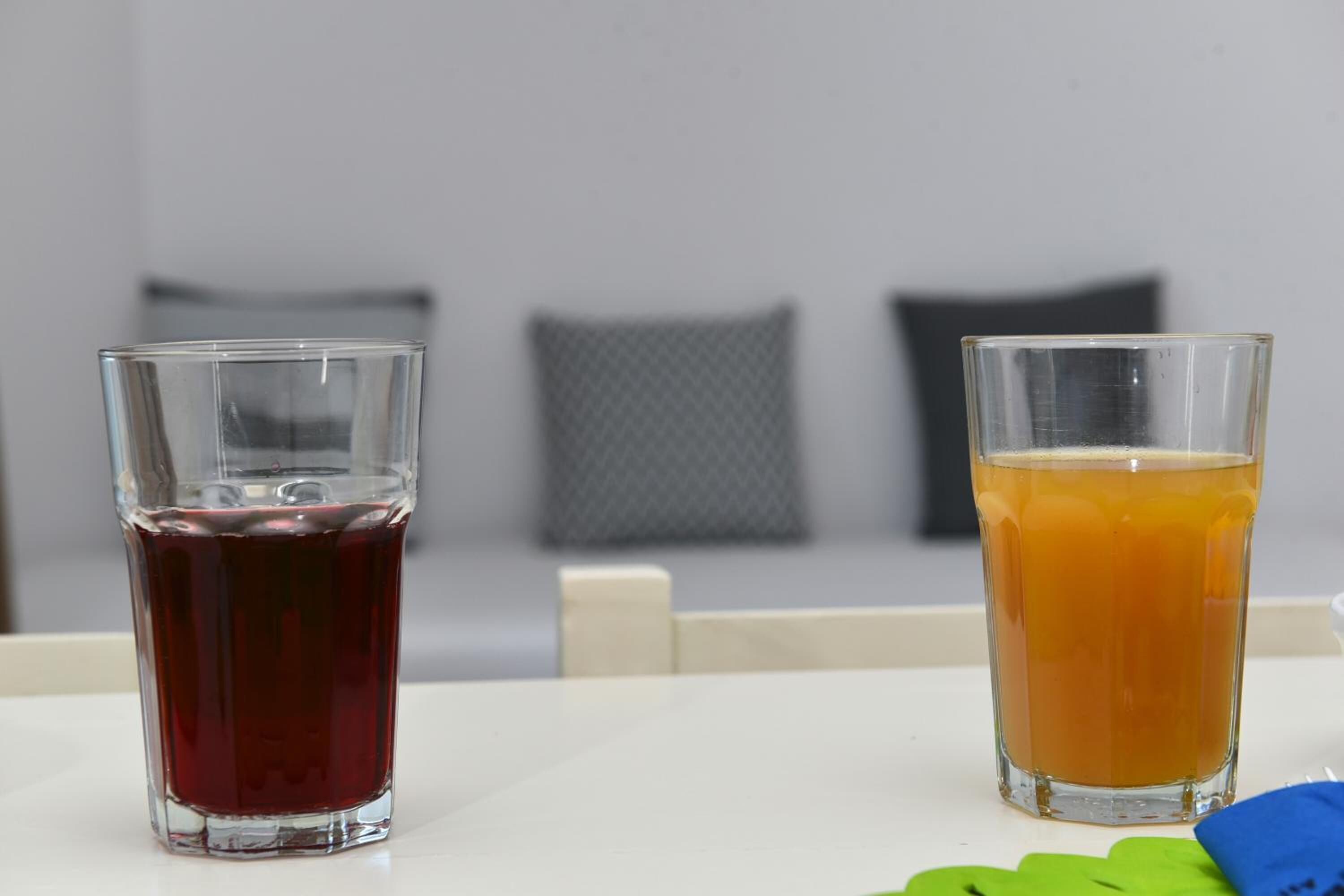 Two glasses of beverages on a table with a white surface.