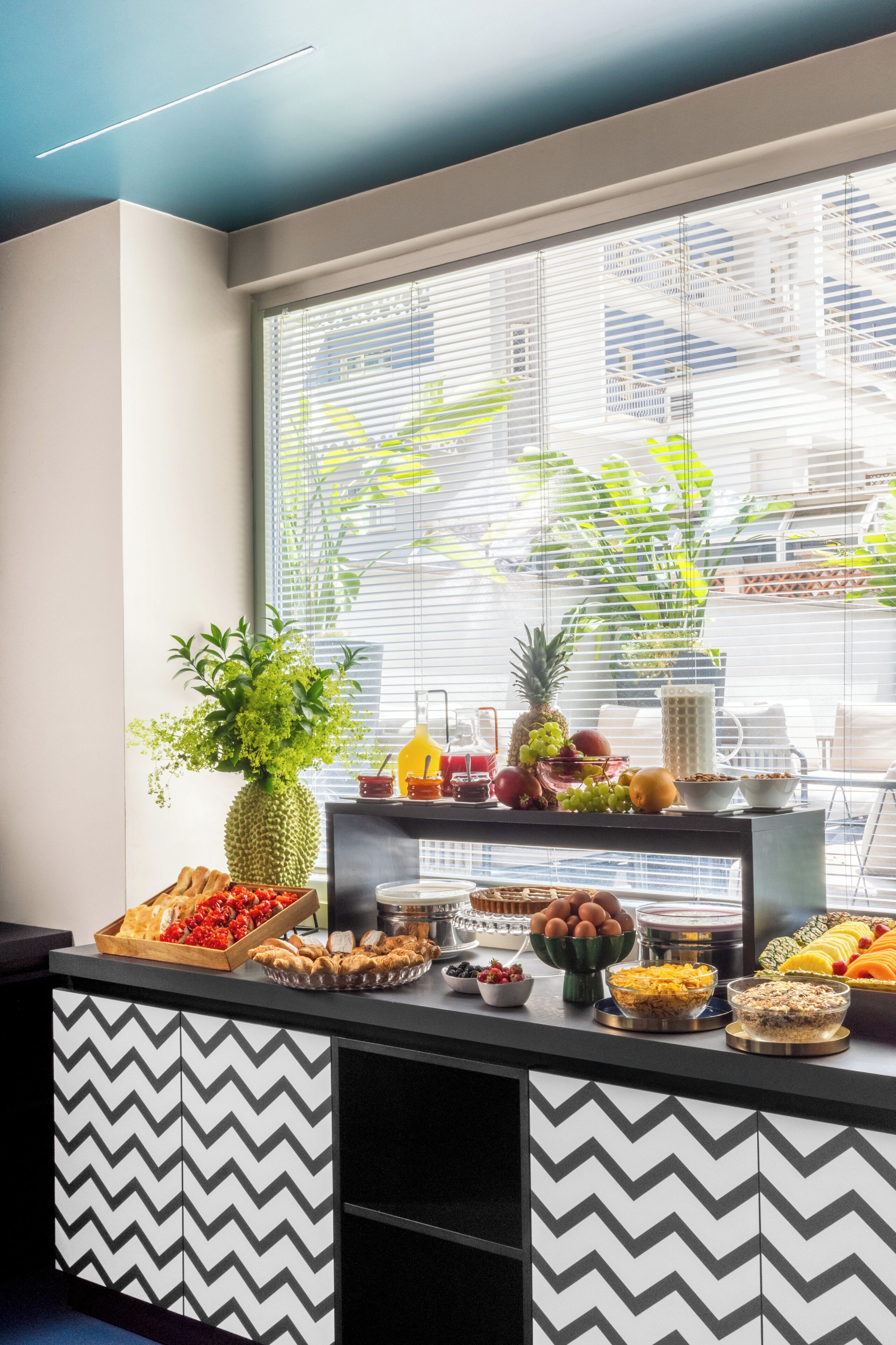 Un buffet de petit-déjeuner proposant une variété d’aliments et agrémenté d’une plante décorative.