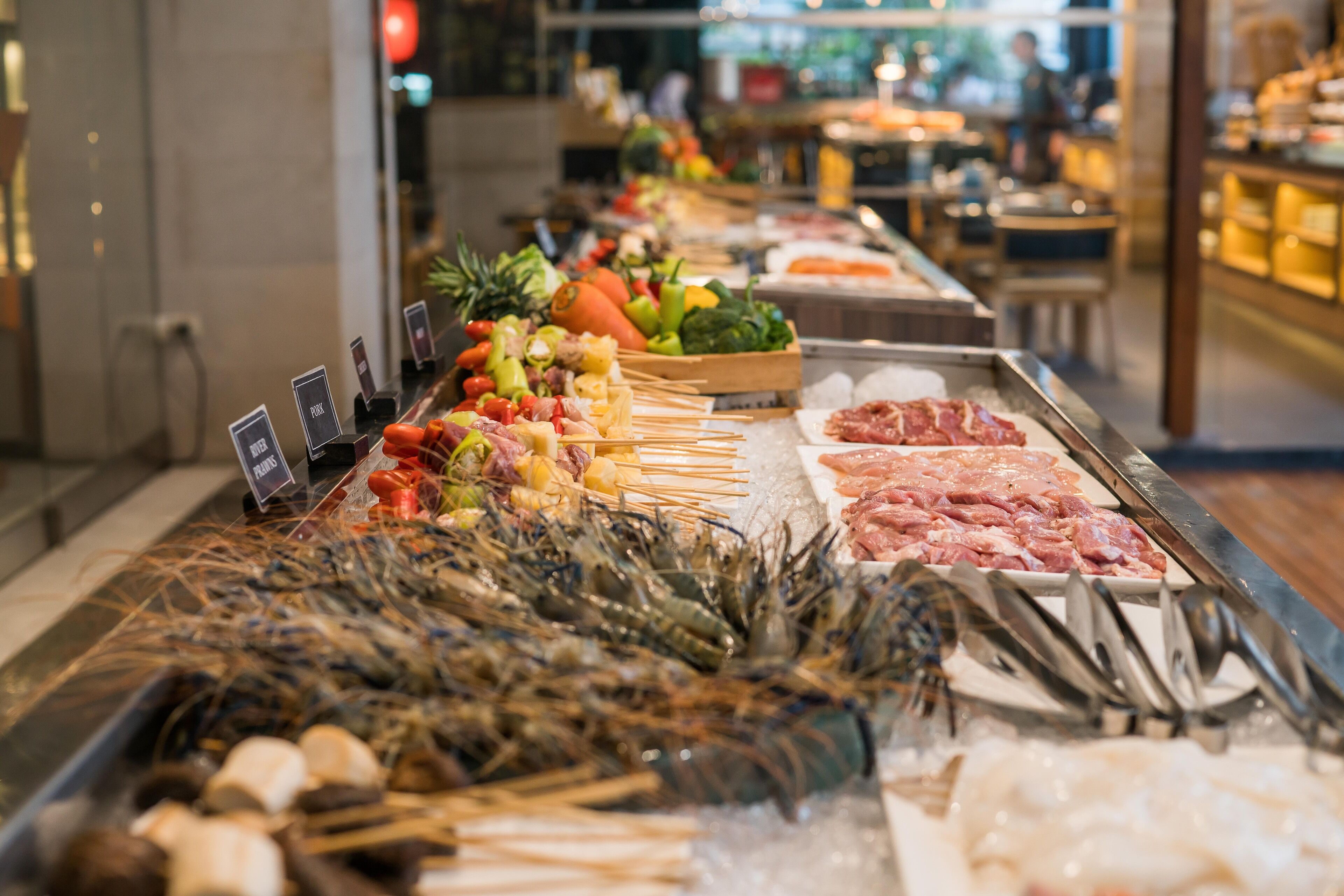 A seafood display with various types of seafood including shrimp, squid, and fish, arranged on ice in a restaurant setting.