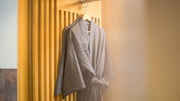 A bathroom with a wooden panel wall and a towel rack with a bathrobe hanging on it.