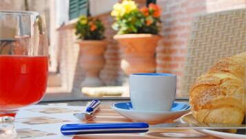 Una mesa con un vaso de bebida roja, una taza, un bolígrafo y un pastel.