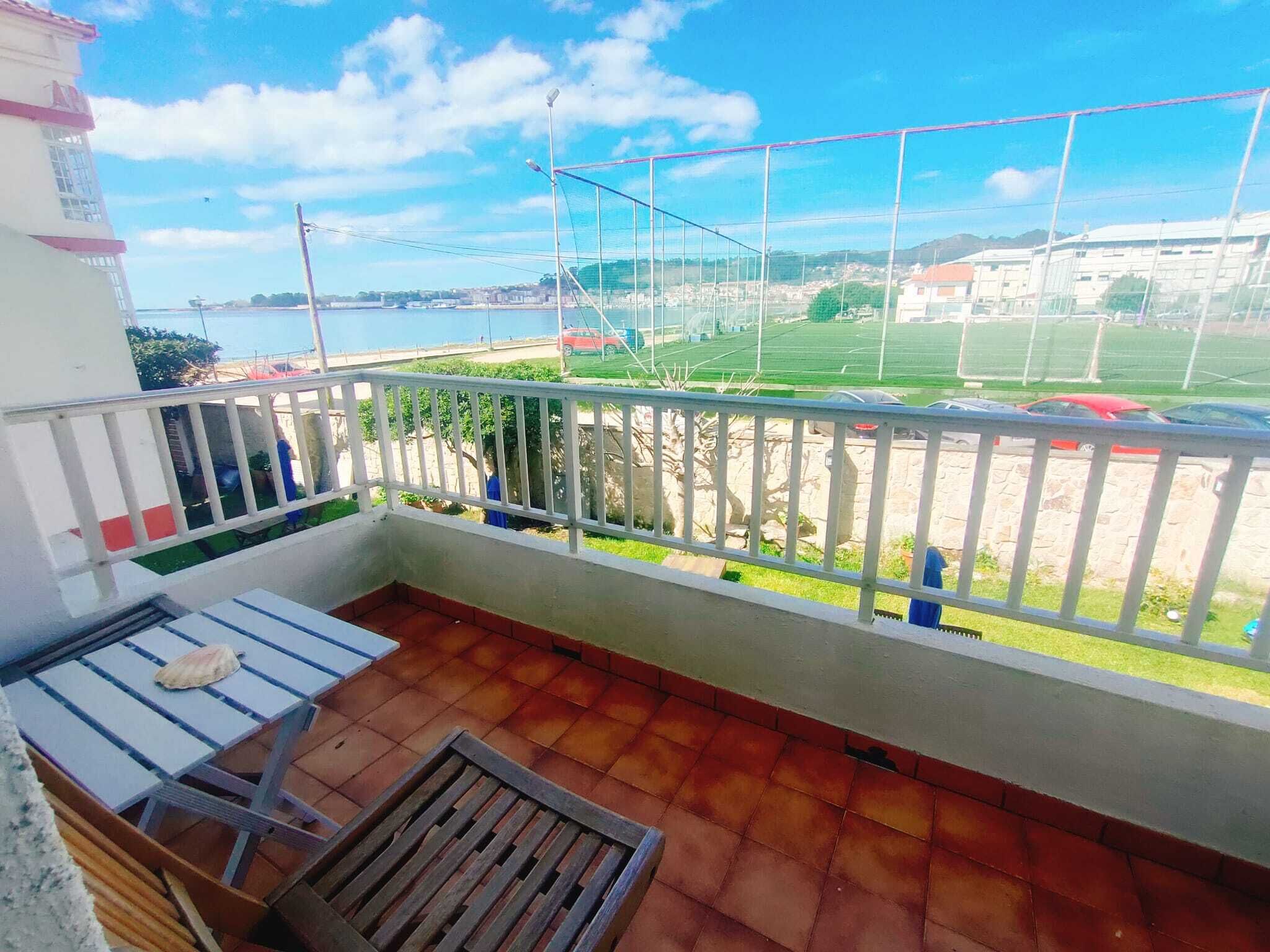 Un balcón con vista a un campo deportivo y edificios.
